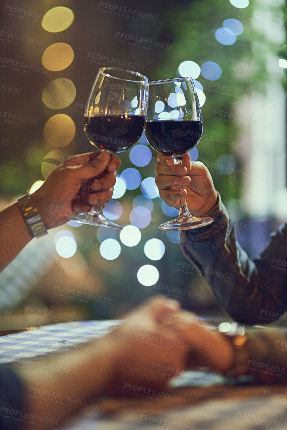 Buy stock photo Cropped shot of a couple clinking their glasses while on a romantic date