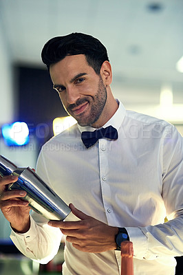 Buy stock photo Portrait of a barman mixing drinks behind the bar in a nightclub