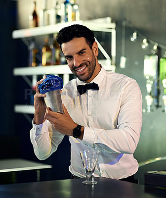 Buy stock photo Portrait of a barman mixing drinks behind the bar in a nightclub