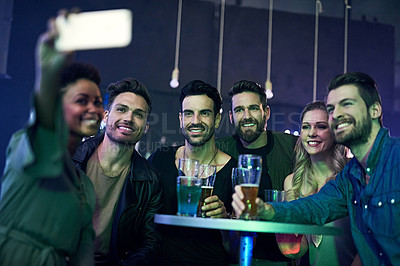 Buy stock photo Shot of a group of young friends taking a selfie together while partying in a nightclub