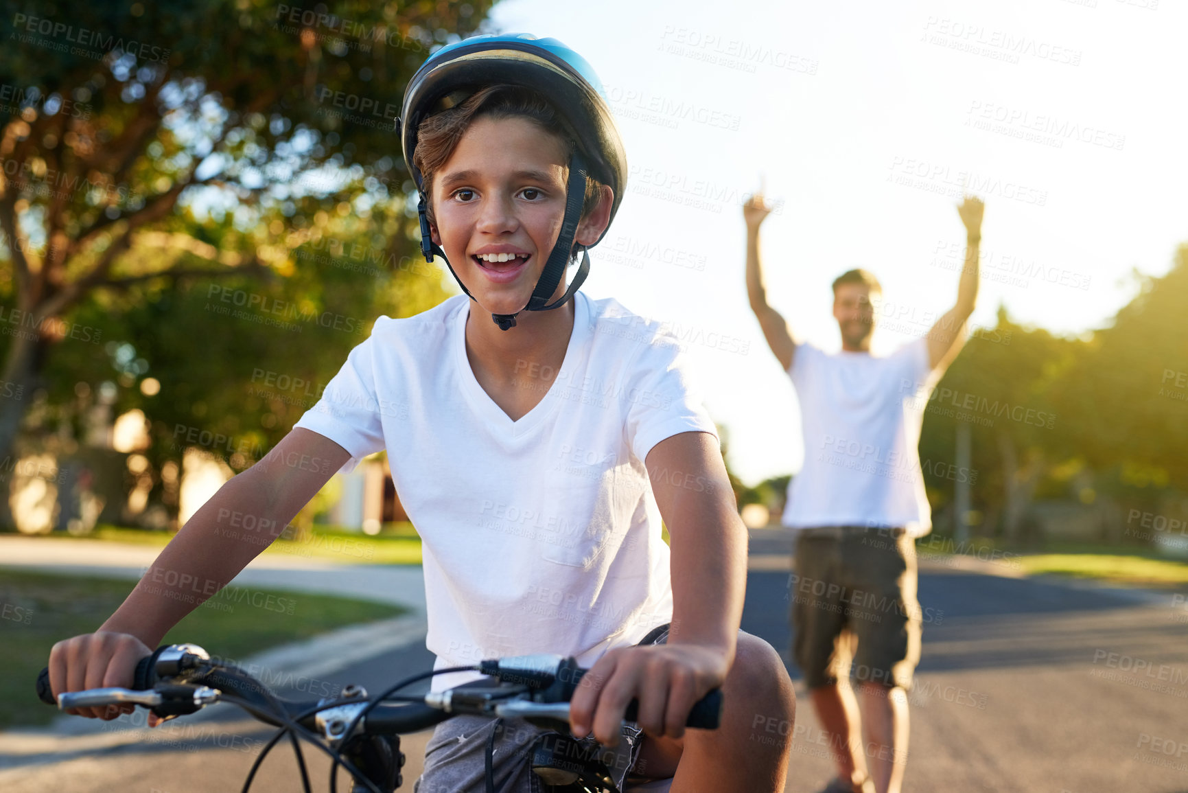 Buy stock photo Shot of a young boy riding his bicycle through his neighbourhood