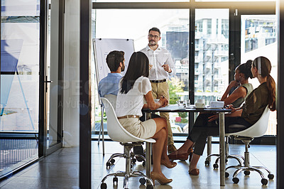 Buy stock photo Shot of a group of man giving a whiteboard presentation to colleagues in a boardroom