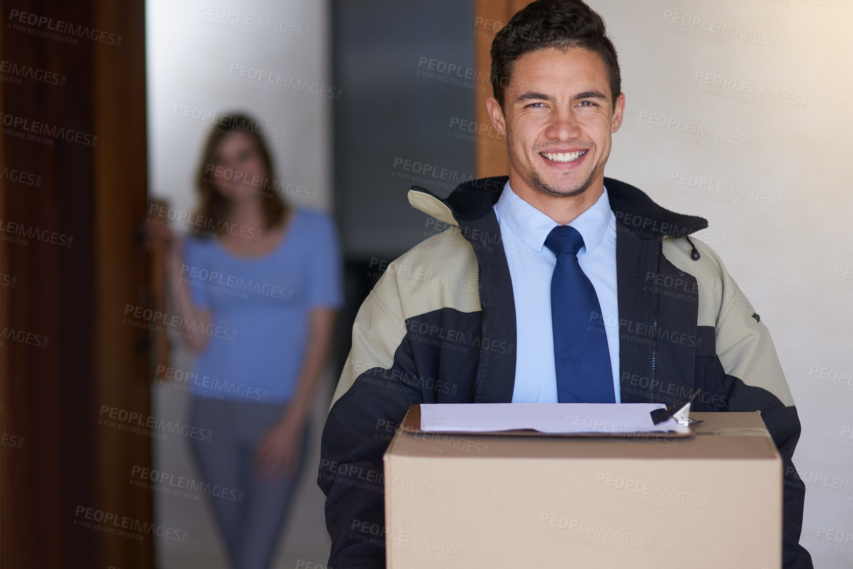 Buy stock photo Shot of a handsome young delivery man making a delivery to a customer at her home