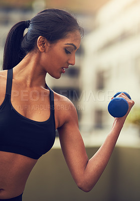 Buy stock photo Cropped shot of a young woman working out with dumbbells
