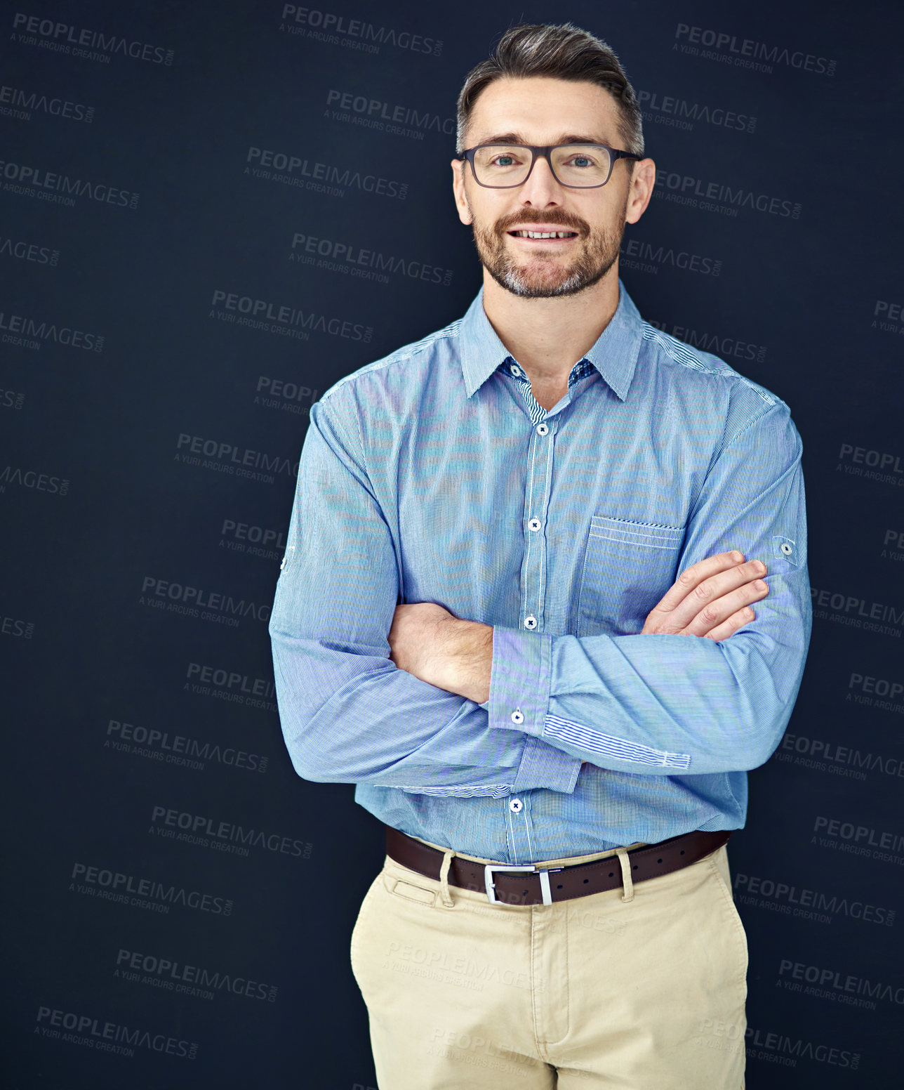 Buy stock photo Businessman, portrait and arms crossed in dark studio with employee isolated on blue background. Smile, manager and about us for company with mockup for pride with director in Germany with glasses