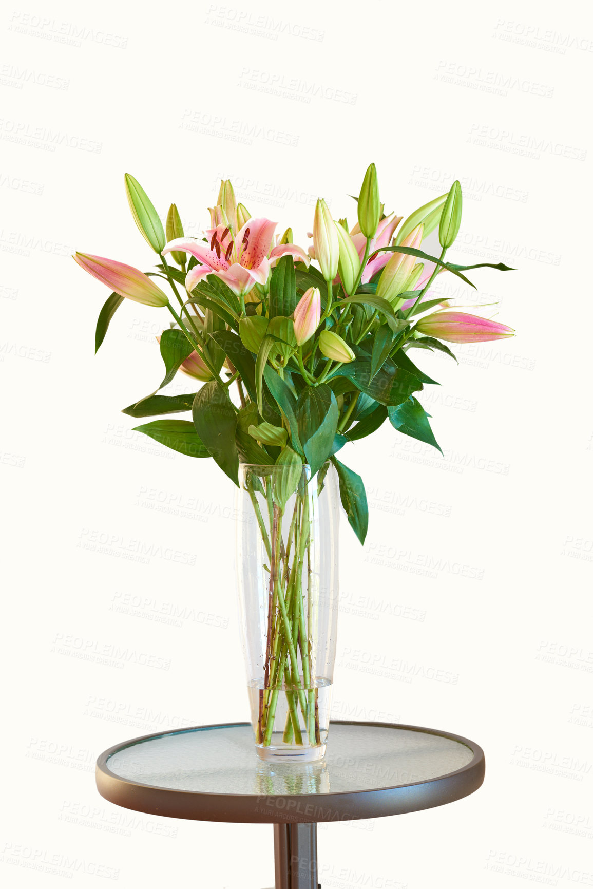 Buy stock photo A gift of pink flowers for valentines day or an anniversary on a table against a white background. Bouquet of fresh lily blooms in a floral arrangement in a glass vase for mothers day present