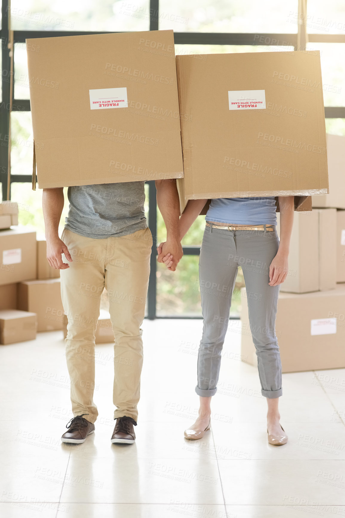 Buy stock photo Couple, boxes and moving to new home, holding hands and property success or investment home loan. People, cardboard and hide or rent apartment for security, relocation and purchase for real estate