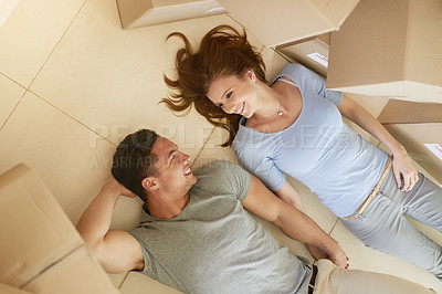Buy stock photo High angle shot of a happy young couple taking a break while moving into their new home together