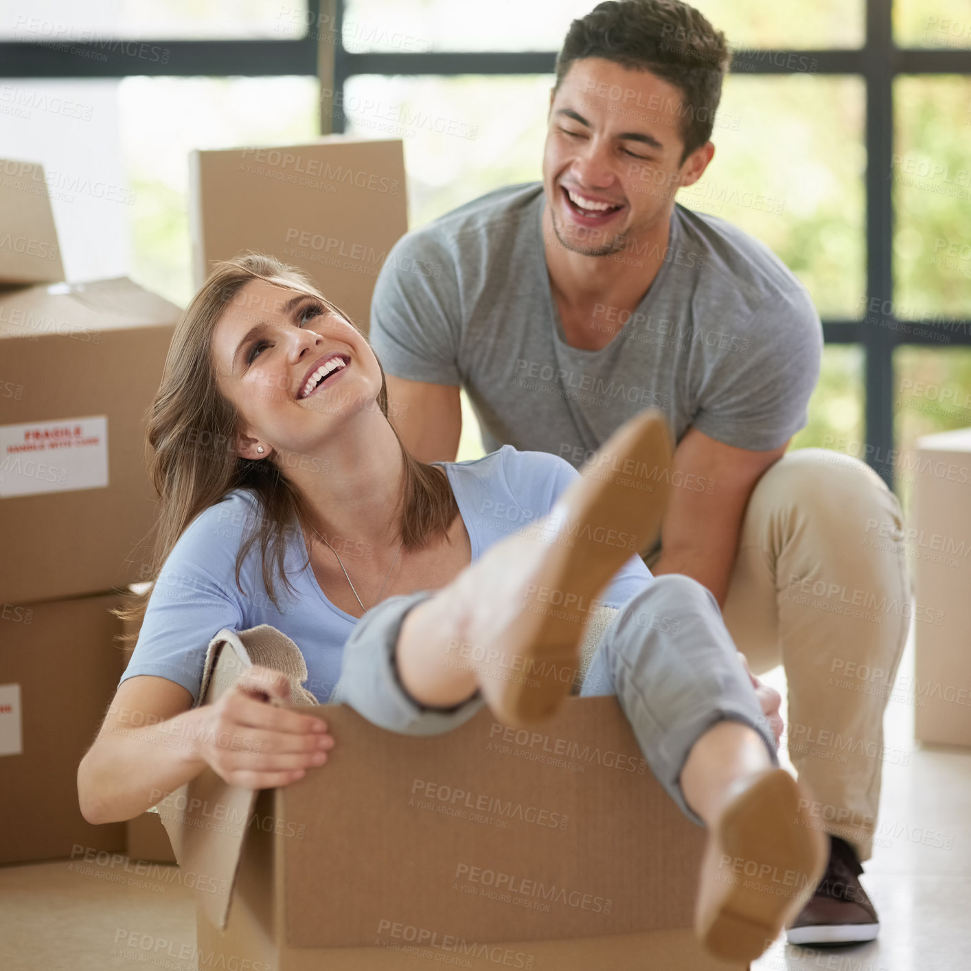 Buy stock photo Happy, couple and moving with boxes in new home for real estate, playing or together for growth. Man, house and woman in cardboard with smile for investment in future, property with mortgage in USA