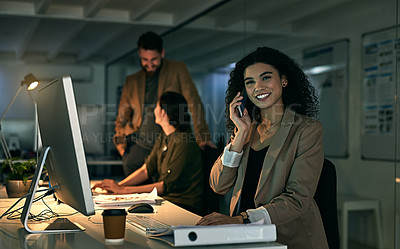 Buy stock photo Shot of a young woman talking on her phone with her colleagues in the background