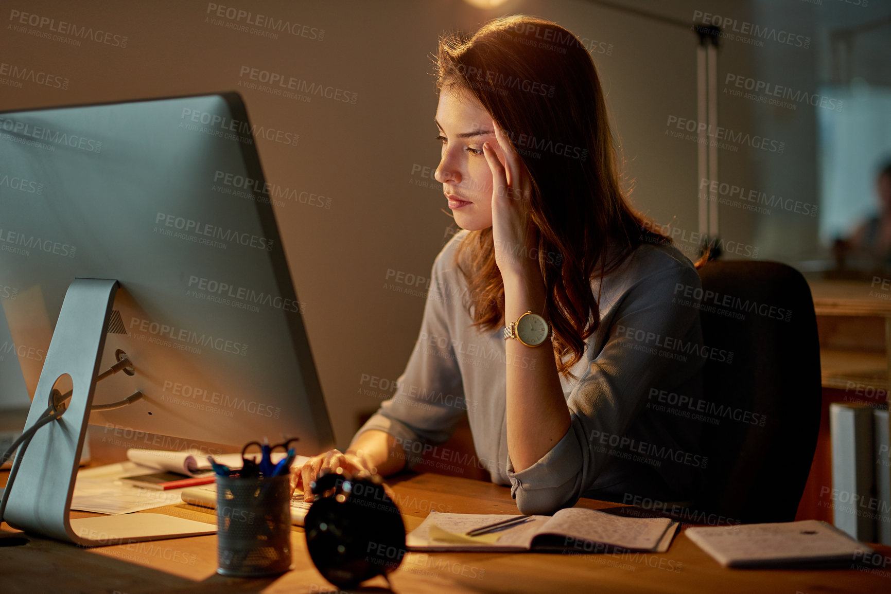 Buy stock photo Shot of an attractive young businesswoman looking stressed while working late in the office