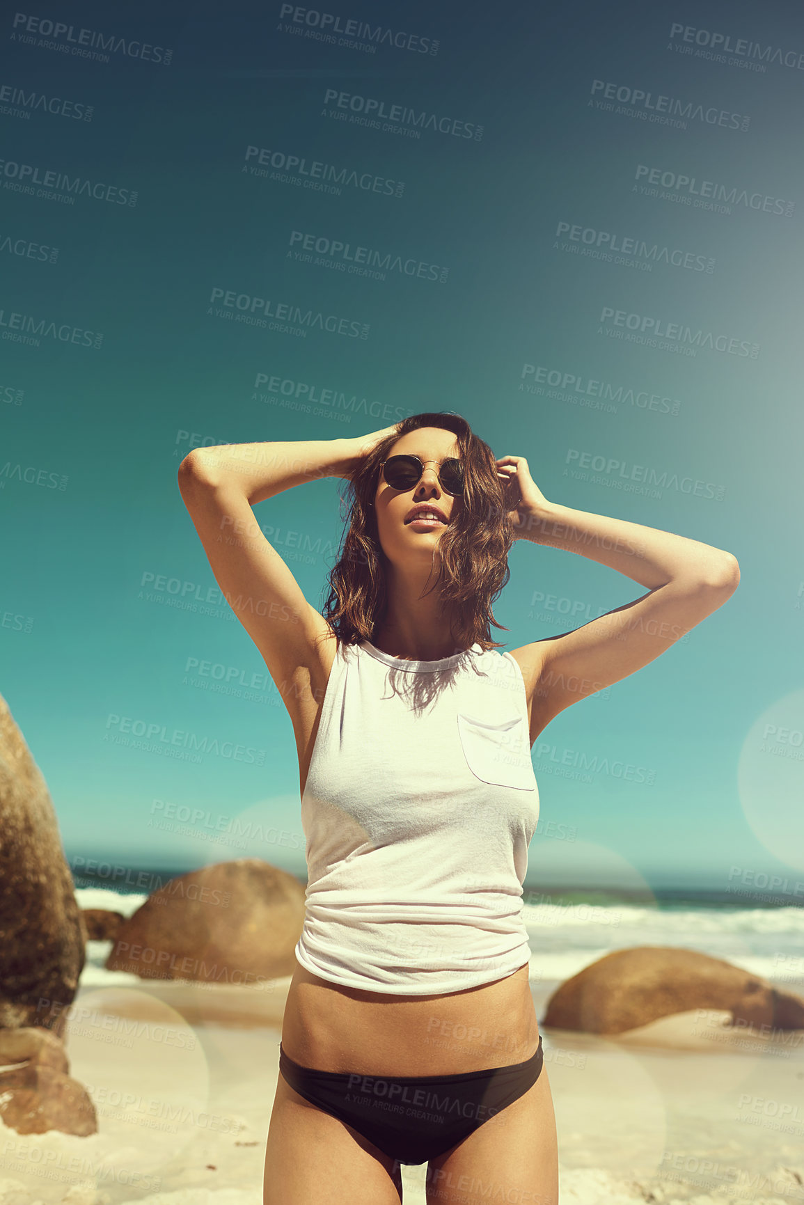 Buy stock photo Shot of an attractive young woman enjoying a day on the beach