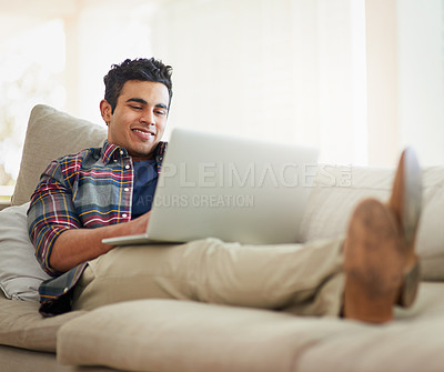 Buy stock photo Man, laptop and home for internet connection with streaming service for free time, stress relief or resting. Male person, smile and couch with technology for online subscription, watching or blogging