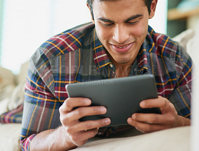 Buy stock photo Man, tablet and reading ebook on sofa for relax weekend in apartment with subscription, entertainment or connection. Male person, technology and browsing service for holiday day off, blog or online
