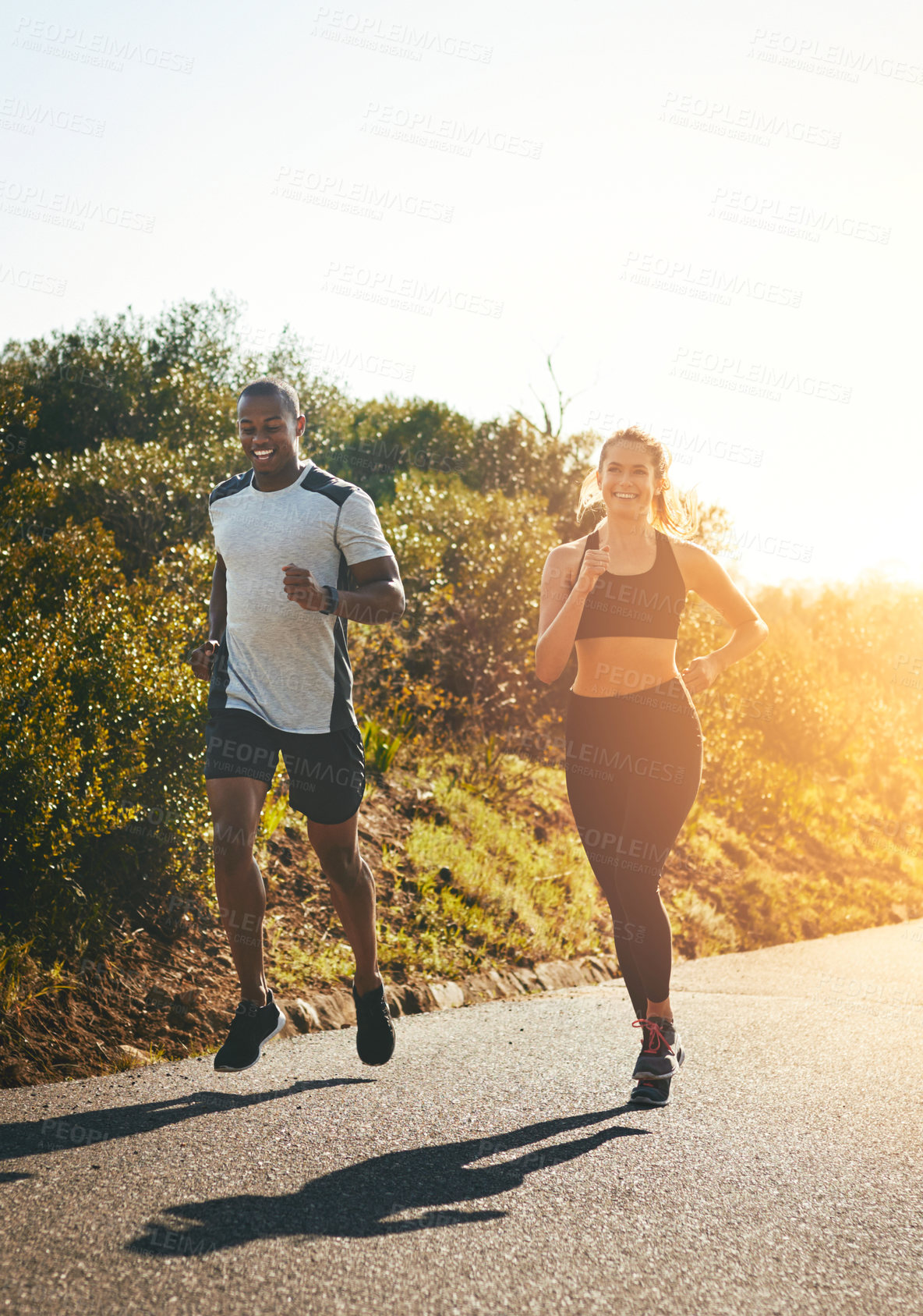 Buy stock photo Freedom, running and happy with couple in road for workout, cardio performance and summer. Marathon, exercise and teamwork with black man and woman runner in nature for sports, training and race