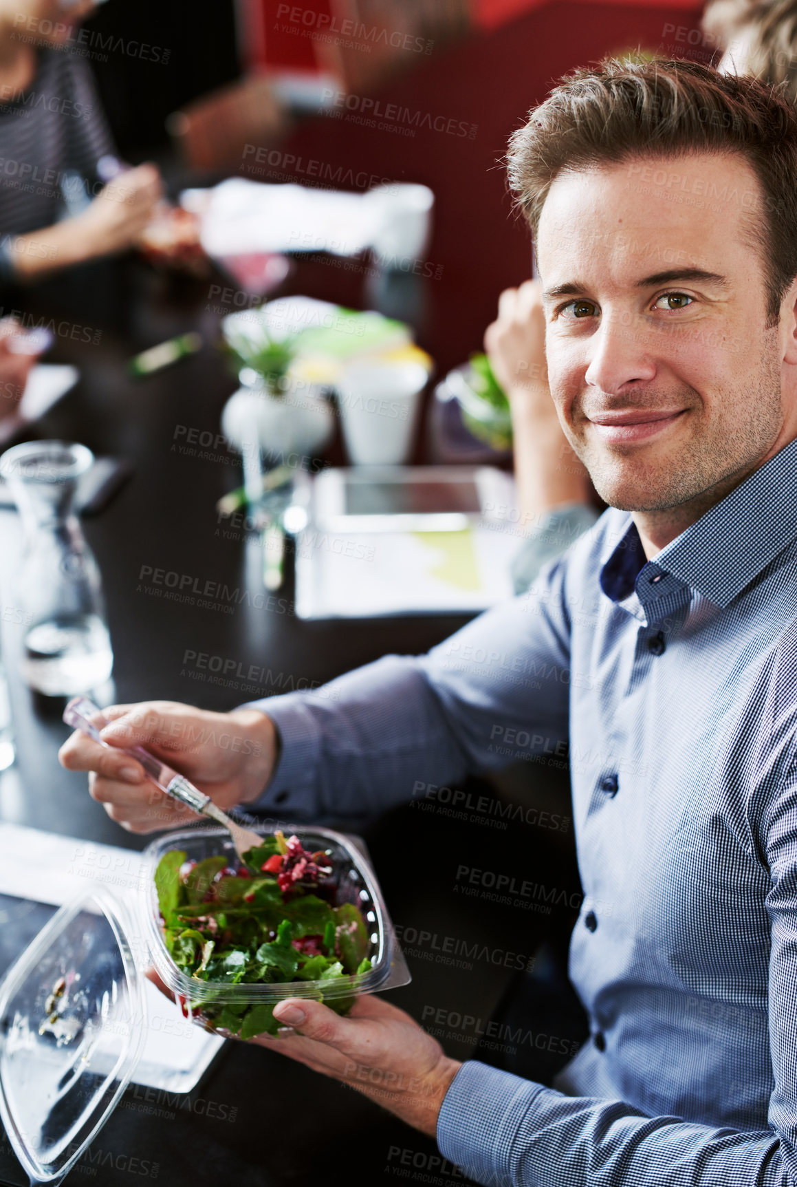 Buy stock photo Meeting, eating and portrait of businessman with salad in office for team building lunch for collaboration. Food, smile and male designer with colleagues enjoying healthy meal in workplace.