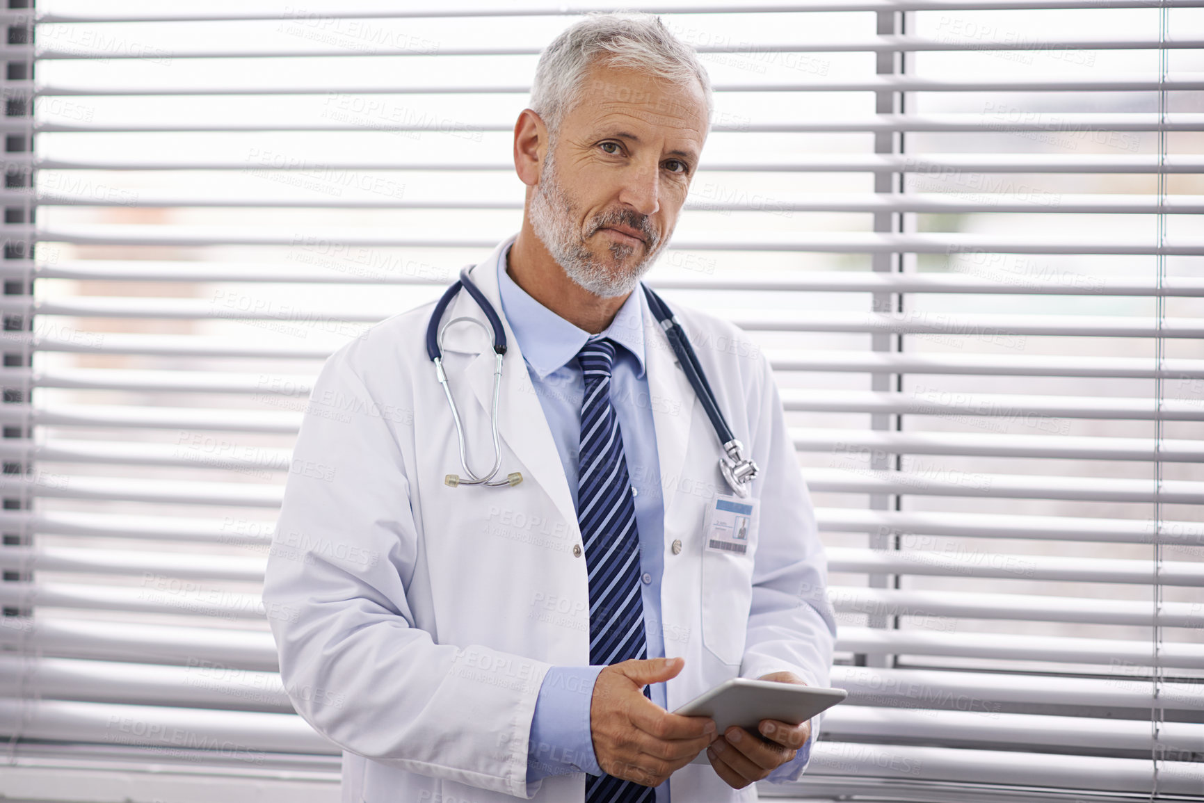 Buy stock photo Portrait of a mature male doctor holding a digital tablet