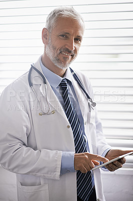Buy stock photo Portrait of a mature male doctor using a digital tablet