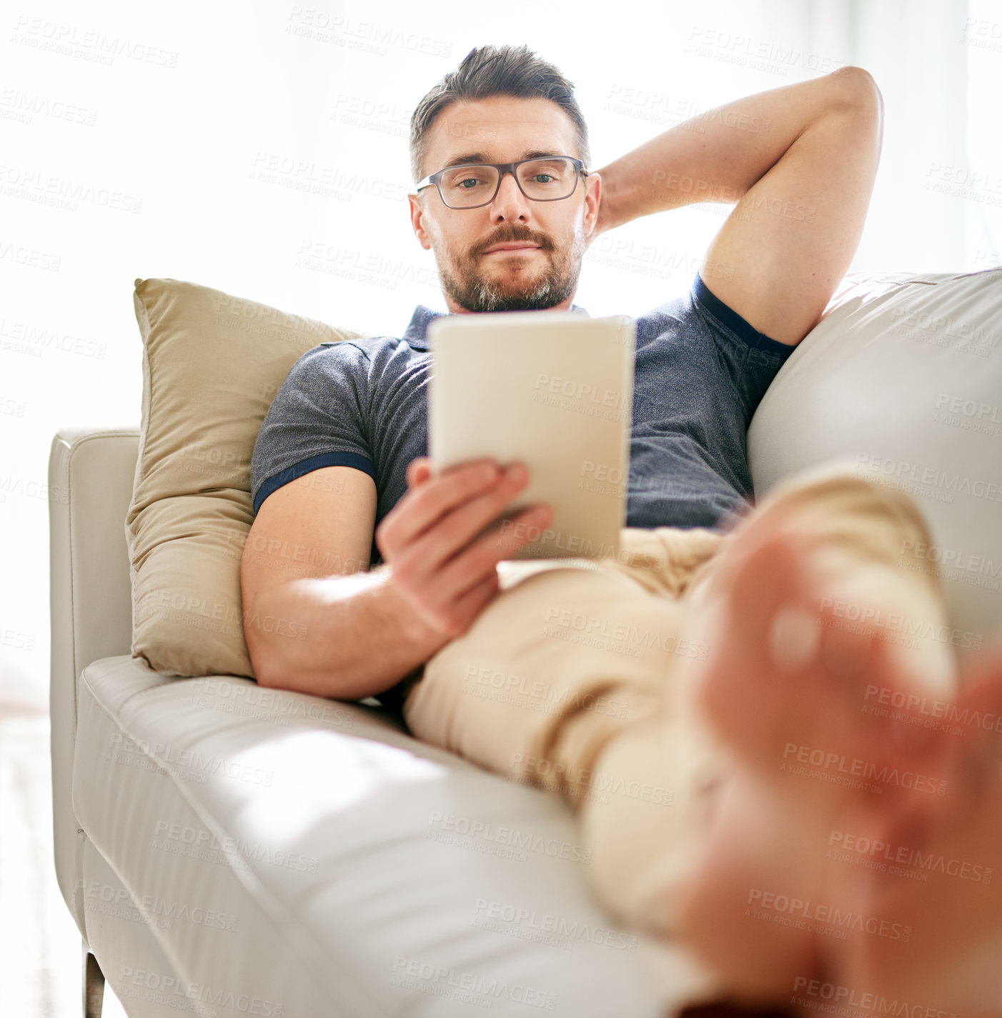 Buy stock photo Tablet, sofa and man relaxing at his home reading a ebook or online blog on the internet. Rest, browsing and mature male person watching a video on social media with digital technology in living room