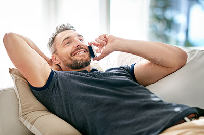 Buy stock photo Happy guy, phonecall and smile for audio conversation, funny joke and good news on sofa in lounge. Young person, cheerful and mobile phone for talk, chatting or speaking for discussion and relax
