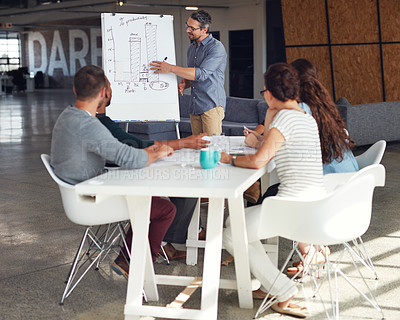 Buy stock photo Shot of a mature man giving a whiteboard presentation to colleagues in an office