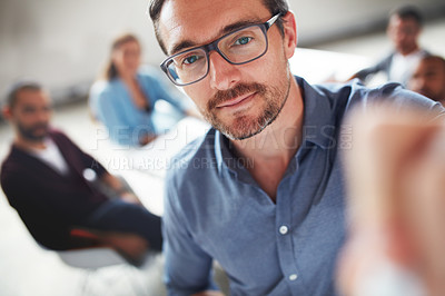 Buy stock photo Shot of a mature man writing on a whiteboard while giving a presentation to colleagues in an office
