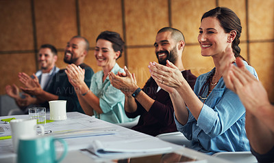 Buy stock photo Shot of a group of colleagues clapping together at a table in an office