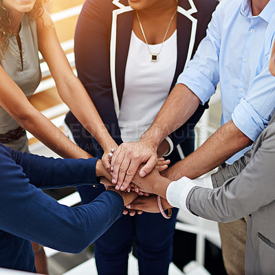 Buy stock photo Shot of a group of coworkers standing with their hands together in a huddle in an office