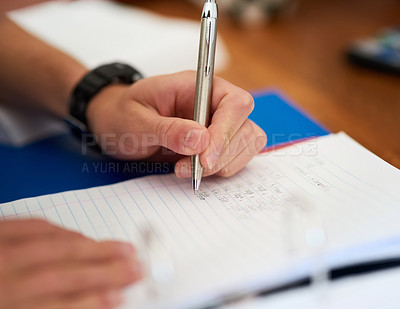 Buy stock photo Closeup shot of an unidentifiable man doing his homework at home