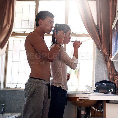 Buy stock photo Couple, together and brushing teeth in bathroom for morning routine or hygiene, dental care for health. Man, woman and toothbrush for cleaning mouth in home with bonding, prevention for gingivitis