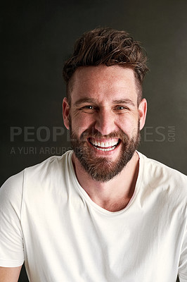 Buy stock photo Portrait of a happy young man posing against a dark background in studio