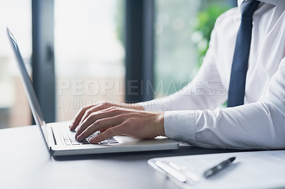 Buy stock photo Cropped shot of a young businessman working on a laptop in an office