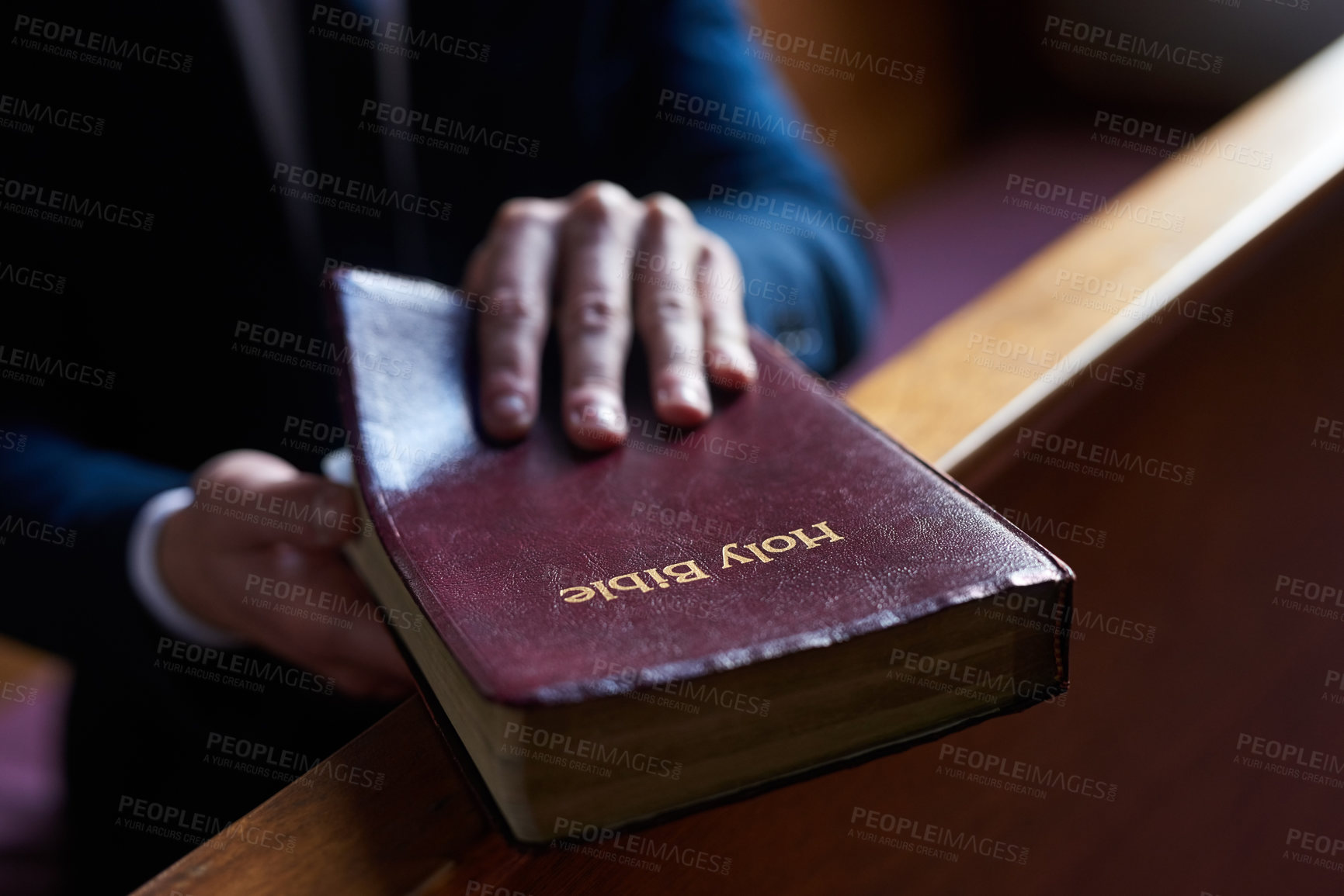 Buy stock photo Cropped shot of a man opening a bible while sitting in a pew at church