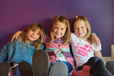 Buy stock photo Portrait of a group of little girls sitting together against a purple background