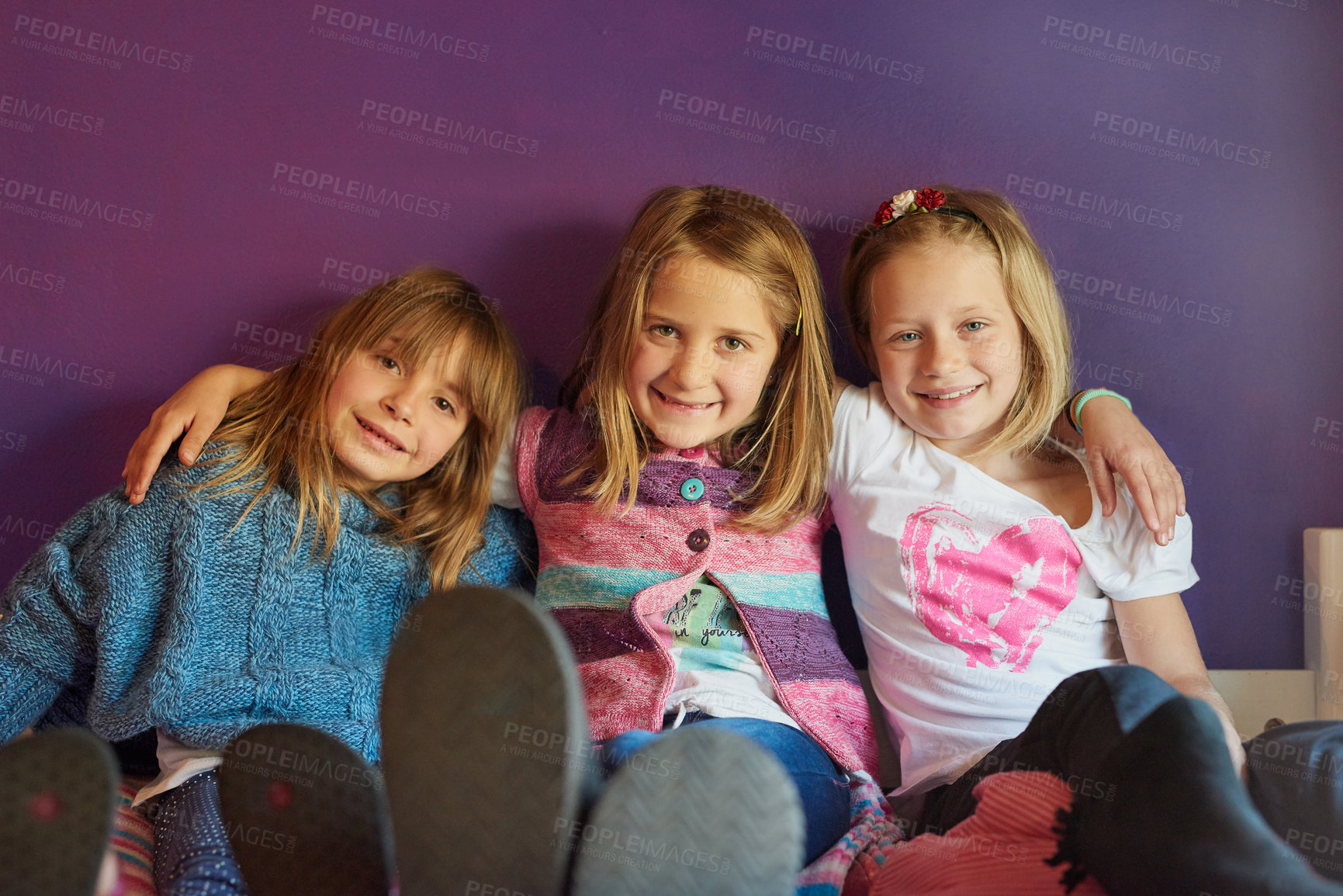 Buy stock photo Portrait of a group of little girls sitting together against a purple background