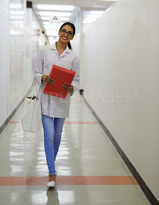Buy stock photo Portrait of an attractive young doctor walking down a passage in a medical center