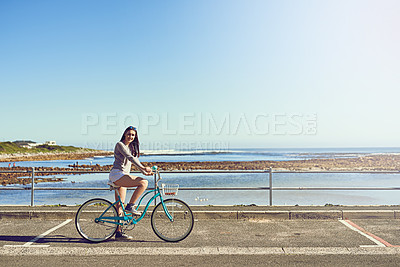 Buy stock photo Portrait of an attractive young woman riding her bicycle outside