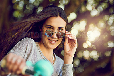 Buy stock photo Portrait of an attractive young woman riding her bicycle outside