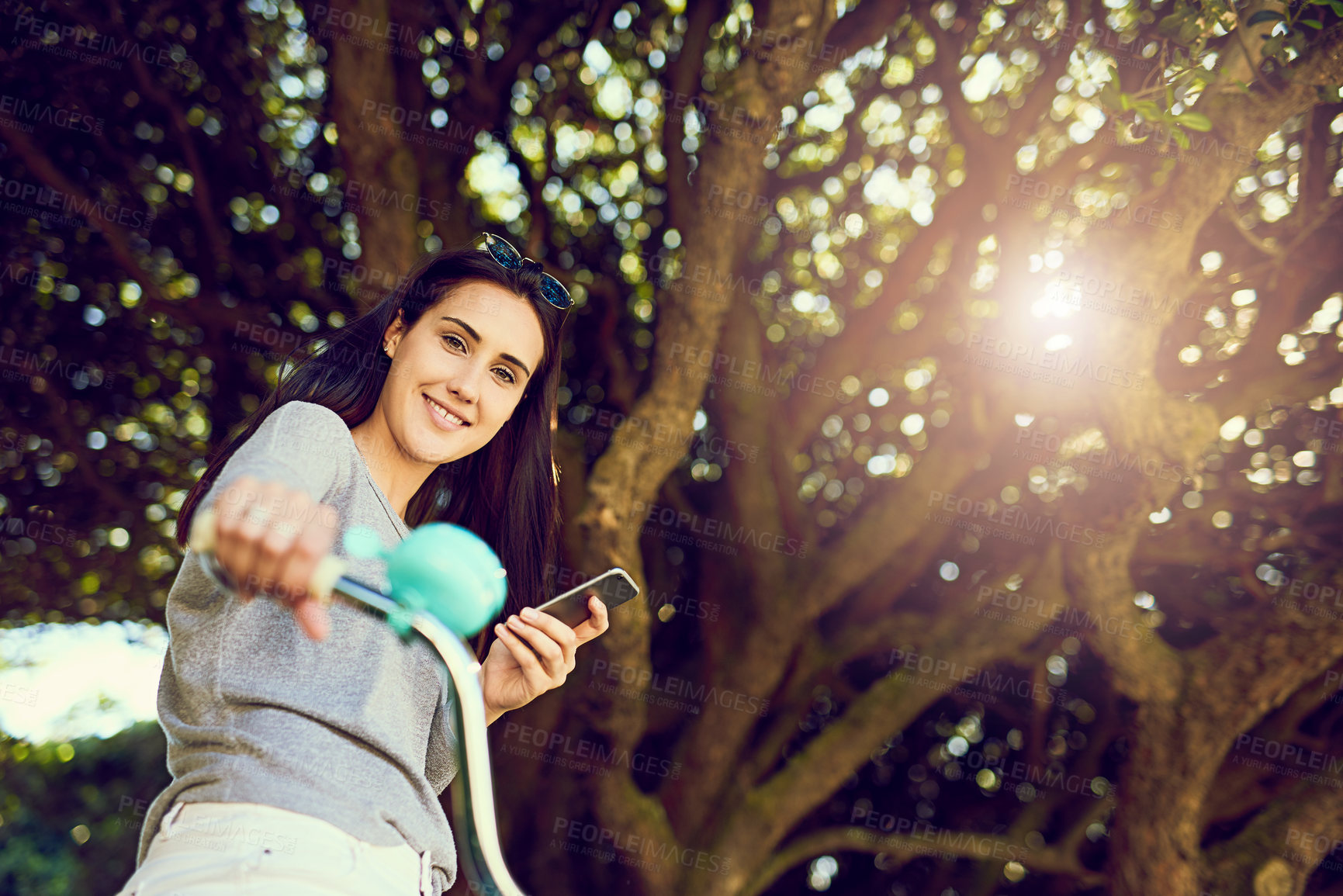 Buy stock photo Bike, cycling and woman with portrait, outdoor and activity with smile and cellphone. Girl, happiness and alternative transport with carbon neutral travel, eco friendly and smartphone on bicycle