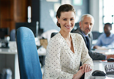 Buy stock photo Portrait of a young woman working at her computer in an office with colleagues in the background