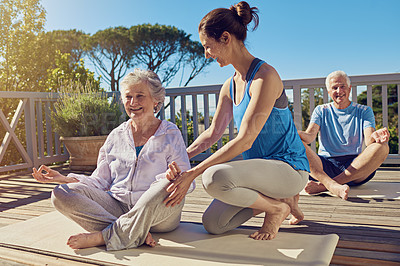 Buy stock photo Shot of a senior couple doing yoga together with an instructor on their patio outside
