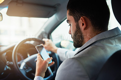 Buy stock photo Cropped shot of a man using his phone while driving