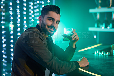Buy stock photo Portrait of a relaxed young man drinking alone in a bar