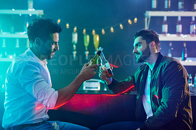 Buy stock photo Barmen, beers and relax after shift in club, bar and rave for party or toast. Men, friends and cheers with bottles for downtime from work at event, festival and nightclub in the city at night
