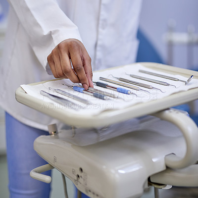 Buy stock photo Closeup shot of an unrecognisable dentist working with a tray of surgical instruments