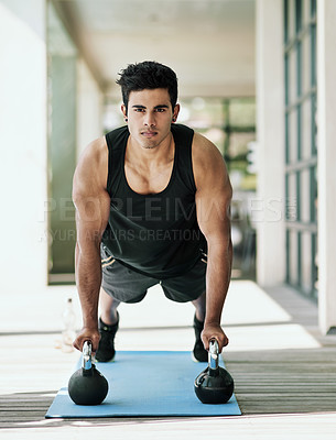 Buy stock photo Portrait of a young man doing pushups with dumbbells at home