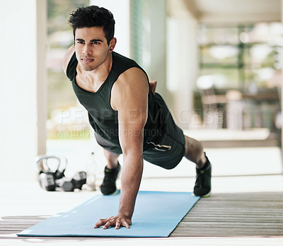 Buy stock photo Portrait of a young man doing pushups during his workout at home
