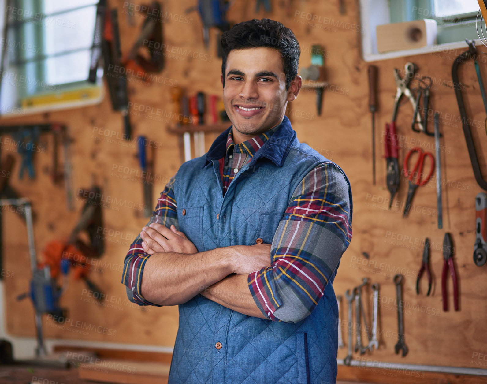 Buy stock photo Arms crossed, portrait and man in workshop with tools for diy project, home renovation and construction startup. Equipment, garage and handyman with smile for building furniture and remodeling house