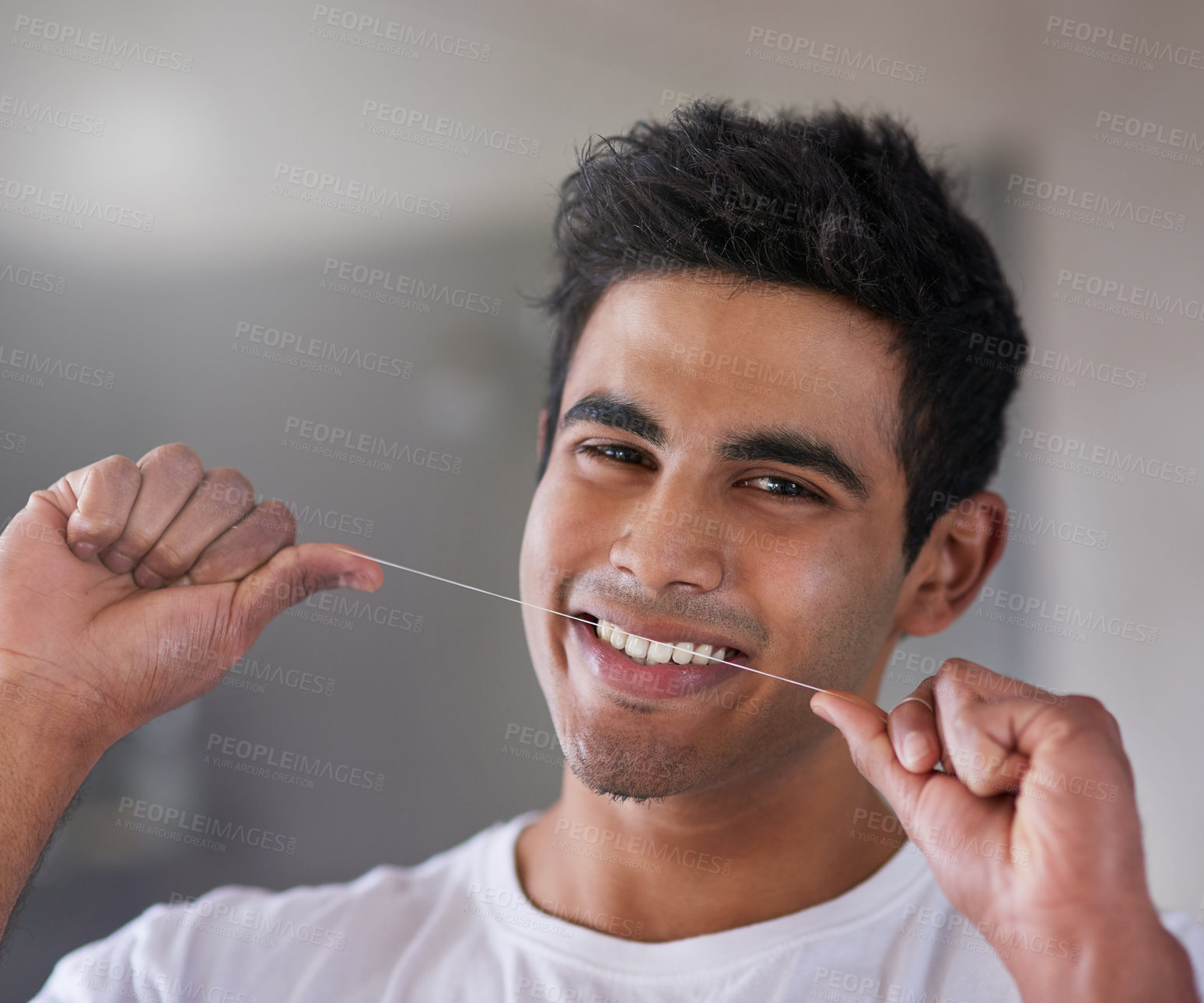 Buy stock photo Portrait of a happy young man flossing his teeth at home