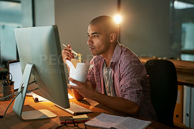 Buy stock photo Cropped shot of a young designer eating takeaways while working late in an office